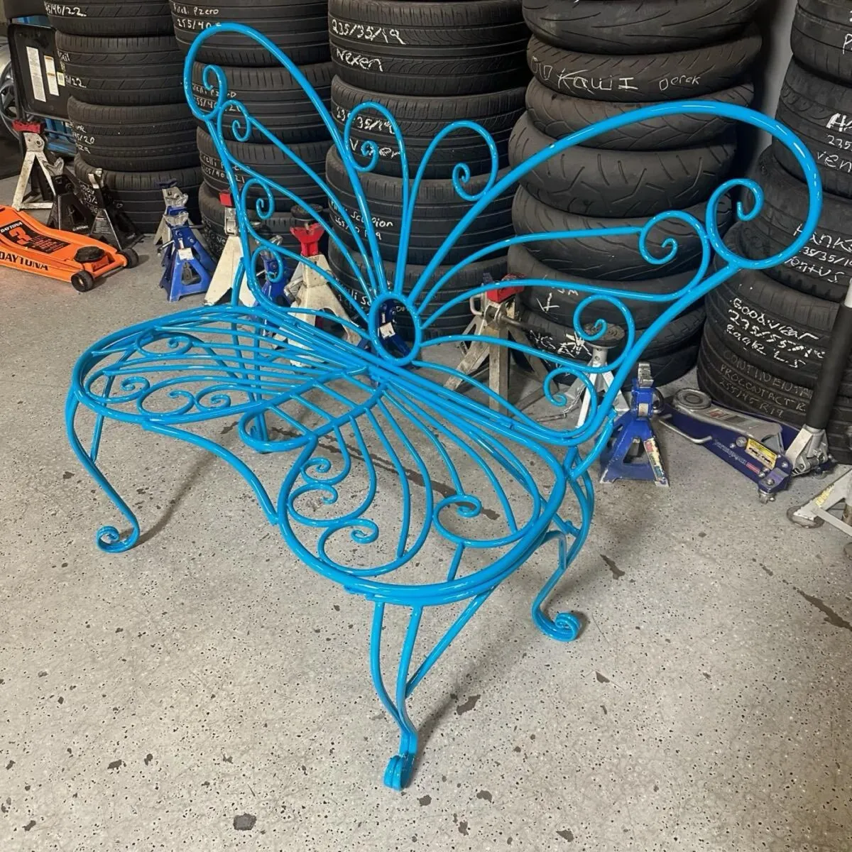 Wrought iron butterfly bench in bright blue.