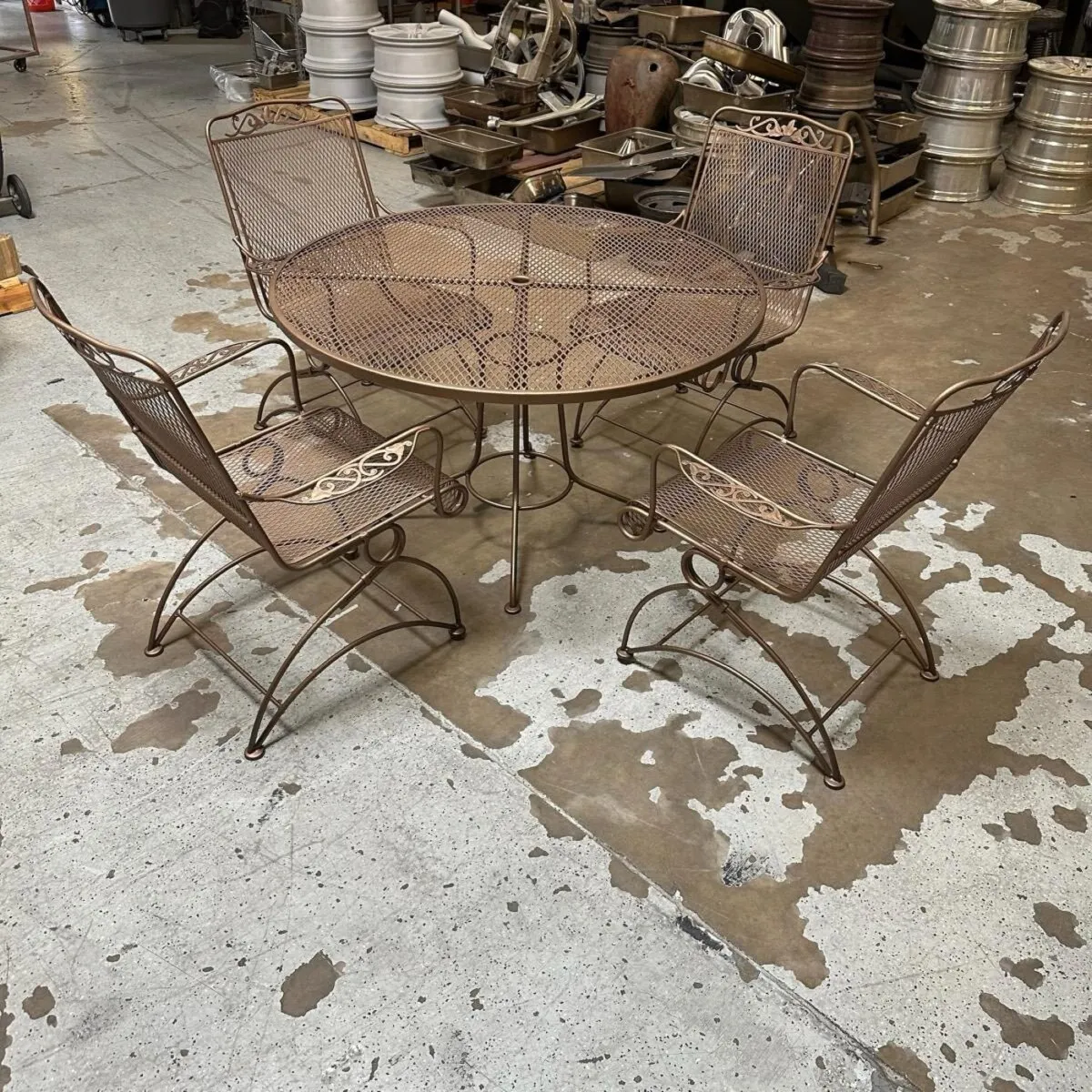 Mesh patio table and chairs in metallic bronze.