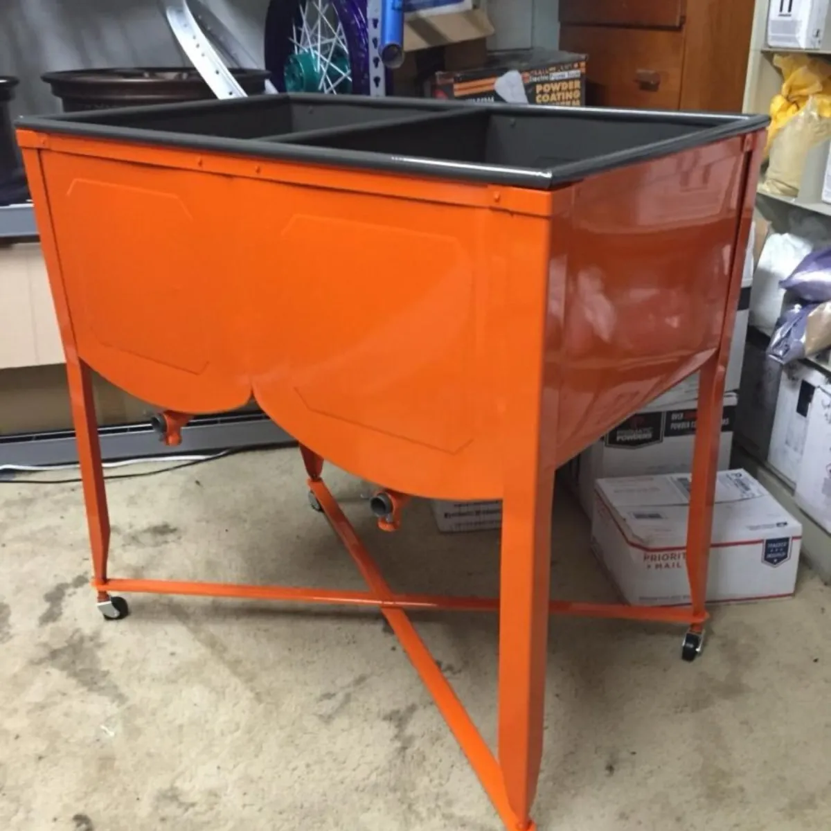 Fabricated steel planter and stand in safety orange.