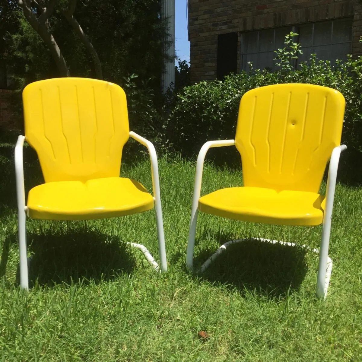 Vintage clamshell lawn chairs in gloss yellow.