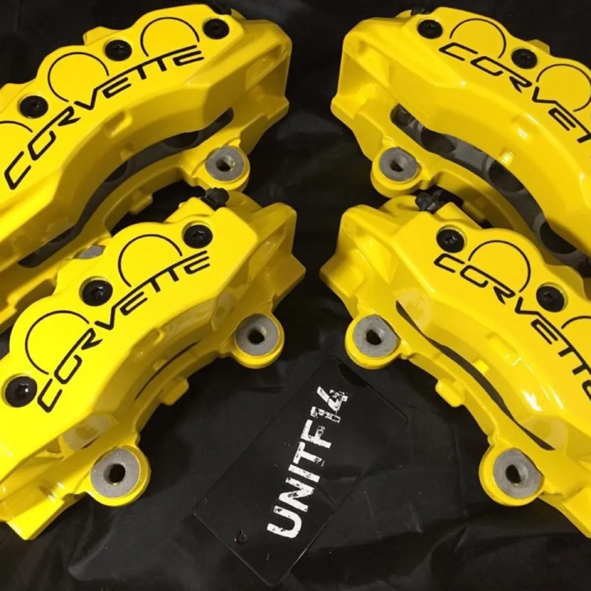 Corvette calipers rebuilt and coated in gloss yellow with black lettering.