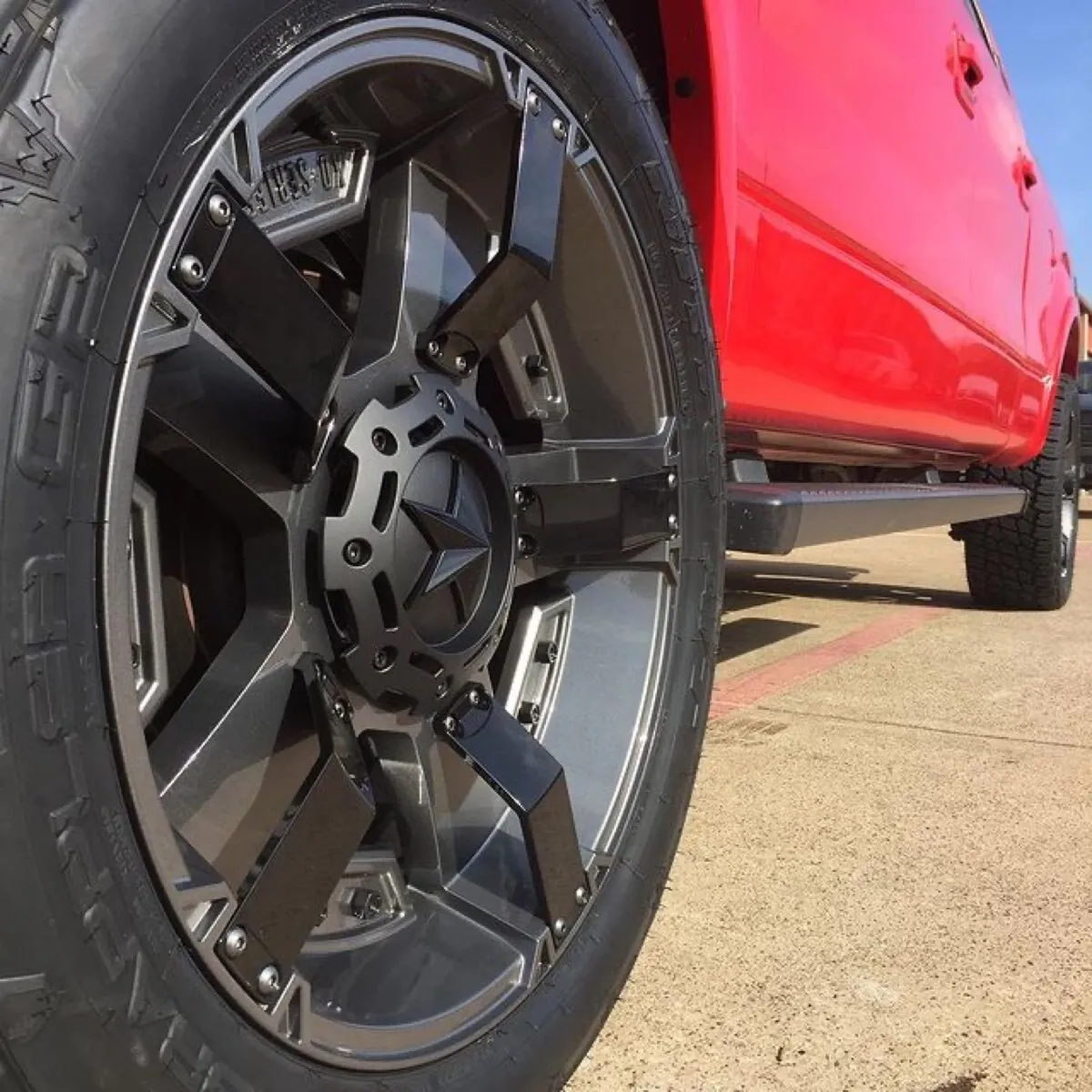 Off-road wheel in gloss black, mounted.