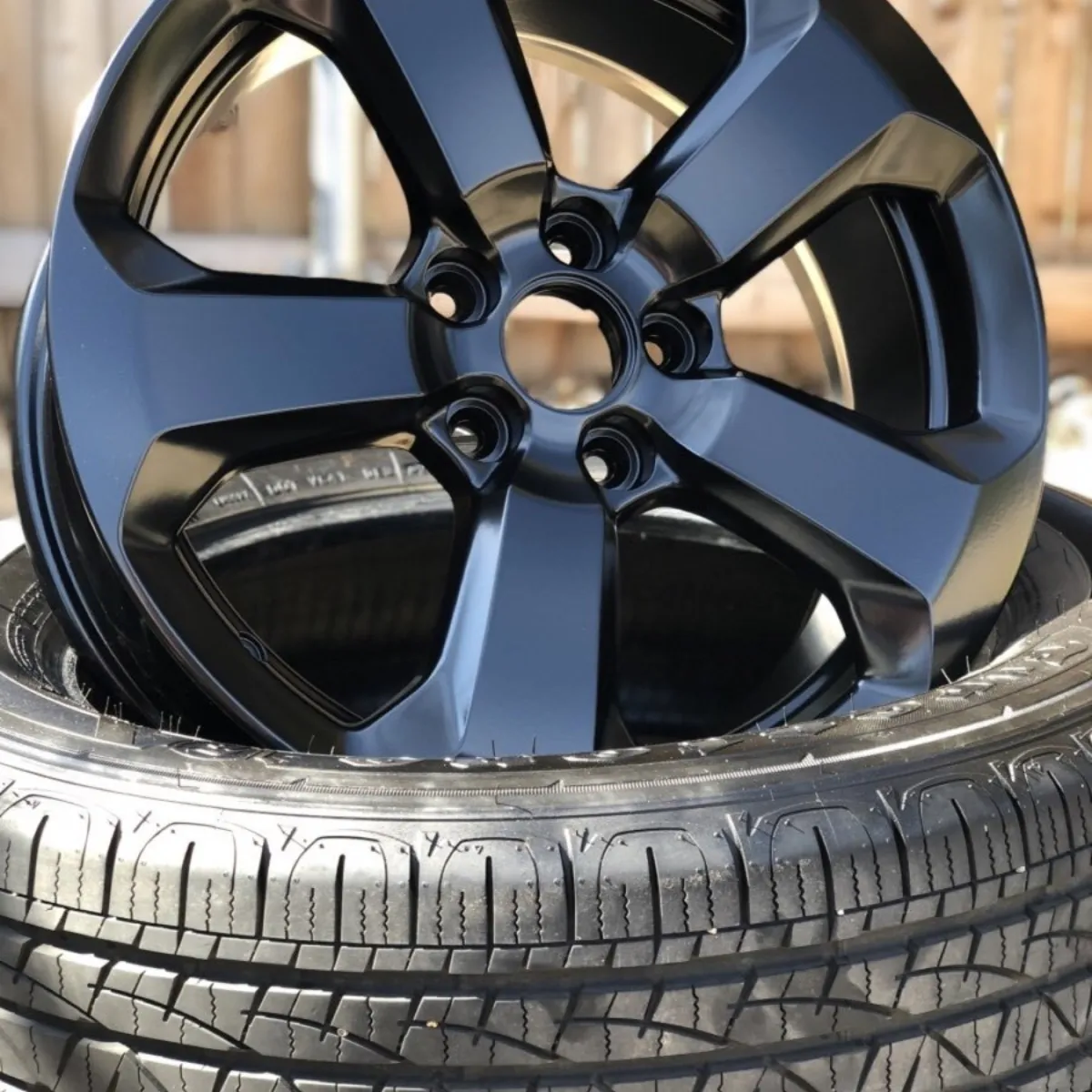 OEM wheel in gloss black, tire mounted in-house.