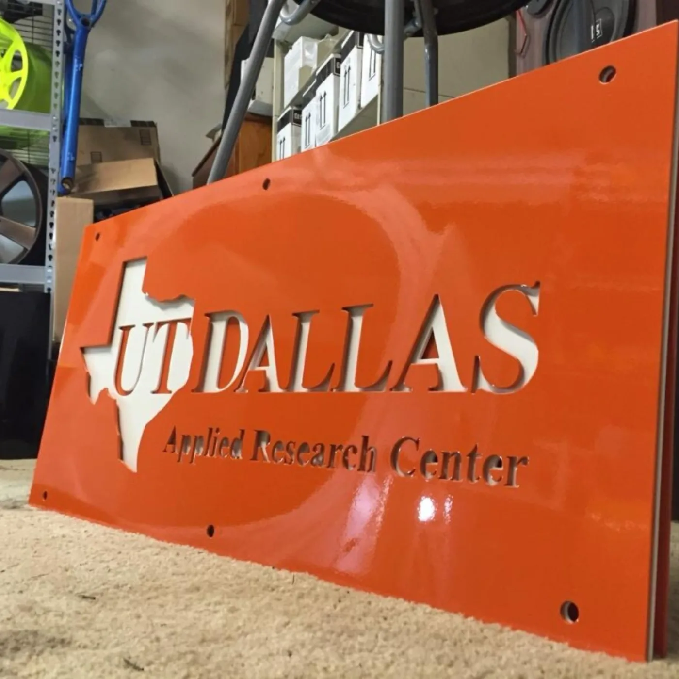 Laser-cut sign for the UT Dallas Applied Research Center in gloss orange.
