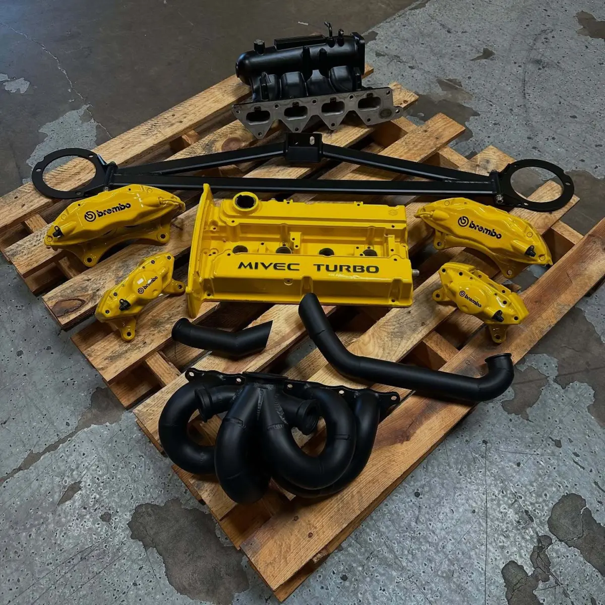 Mitsubishi Evo brake calipers, valve covers, and exhaust components powder coated Hot Yellow and High Temp Glacier Black Cerakote