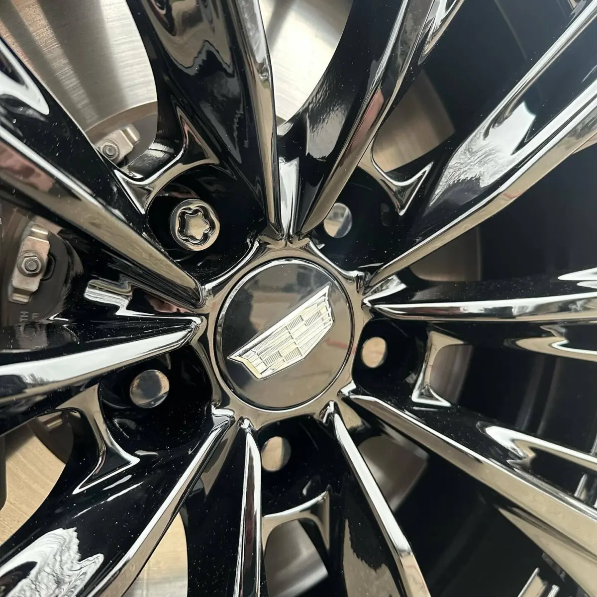 Cadillac CT-5 Blackwing wheels refinished in Wet Black and paired with black chrome lug nuts