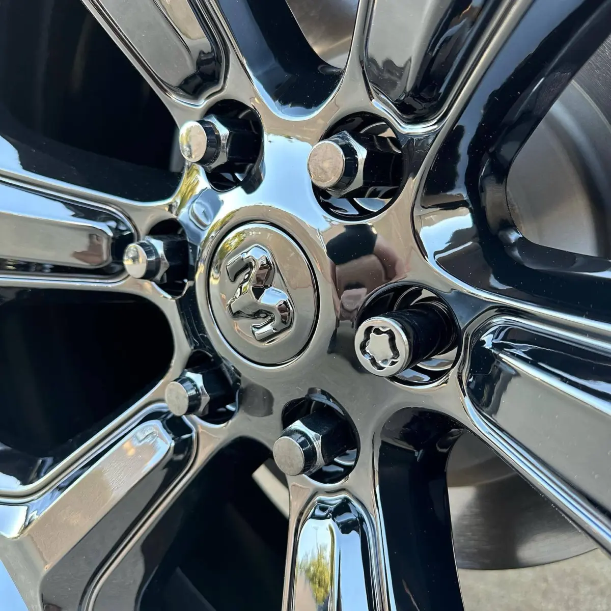 2020 Ram 1500 wheels refinished in Super Mirror Black. Paired with black chrome lug nuts, and painted black center caps