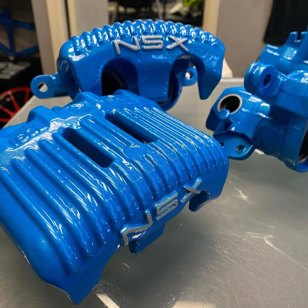 Acura NSX brake calipers refinished in Sparks Blue with Heavy Silver lettering