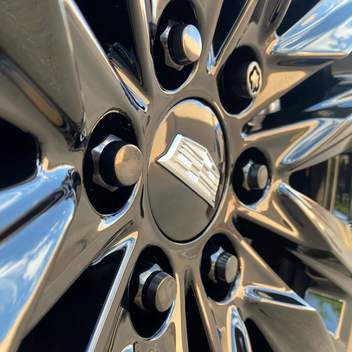 Cadillac Escalade wheels refinished in Super Mirror Black paired with Black Chrome locking lug nuts