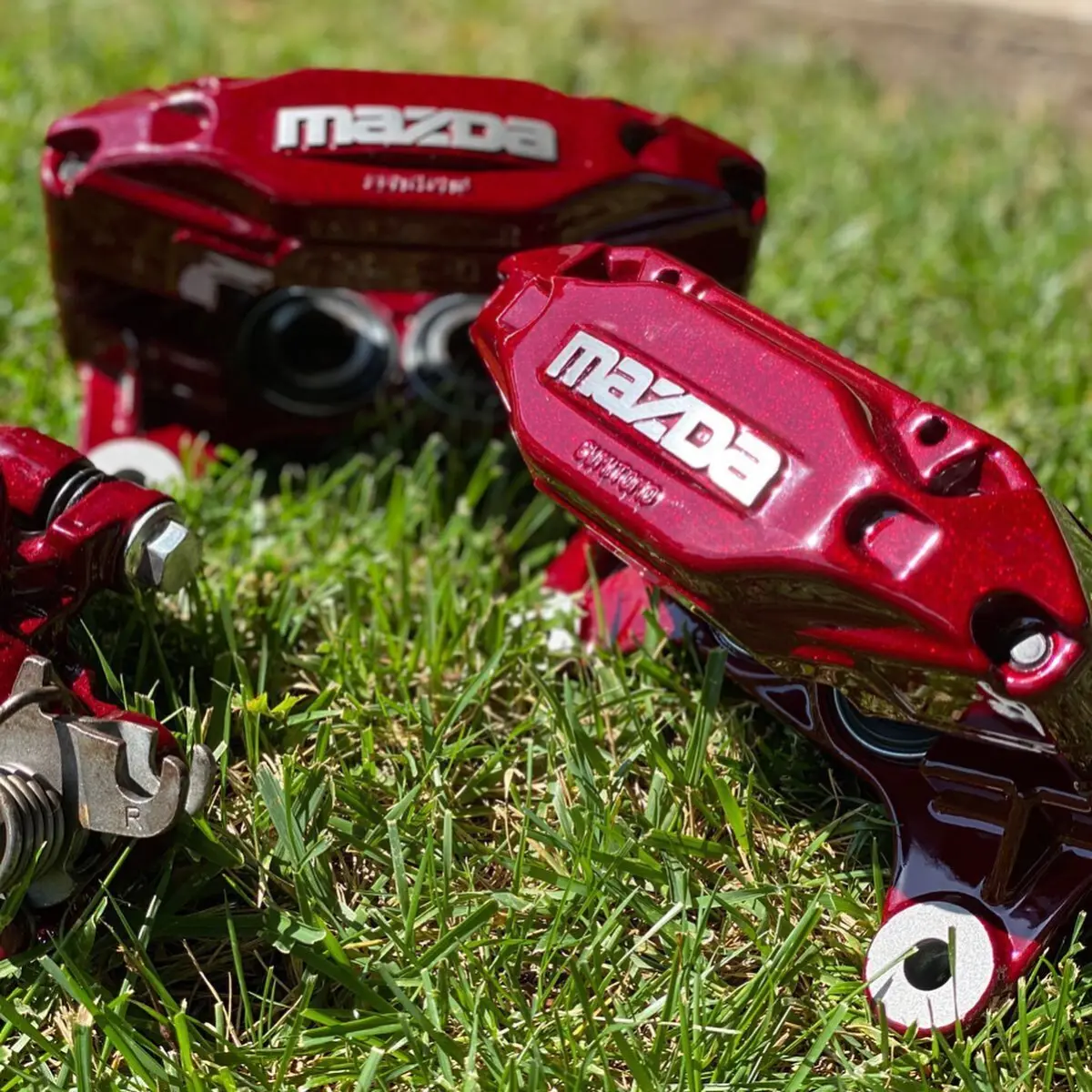 Mazda RX7 brake calipers refinished in Illusion Cherry with brushed letters