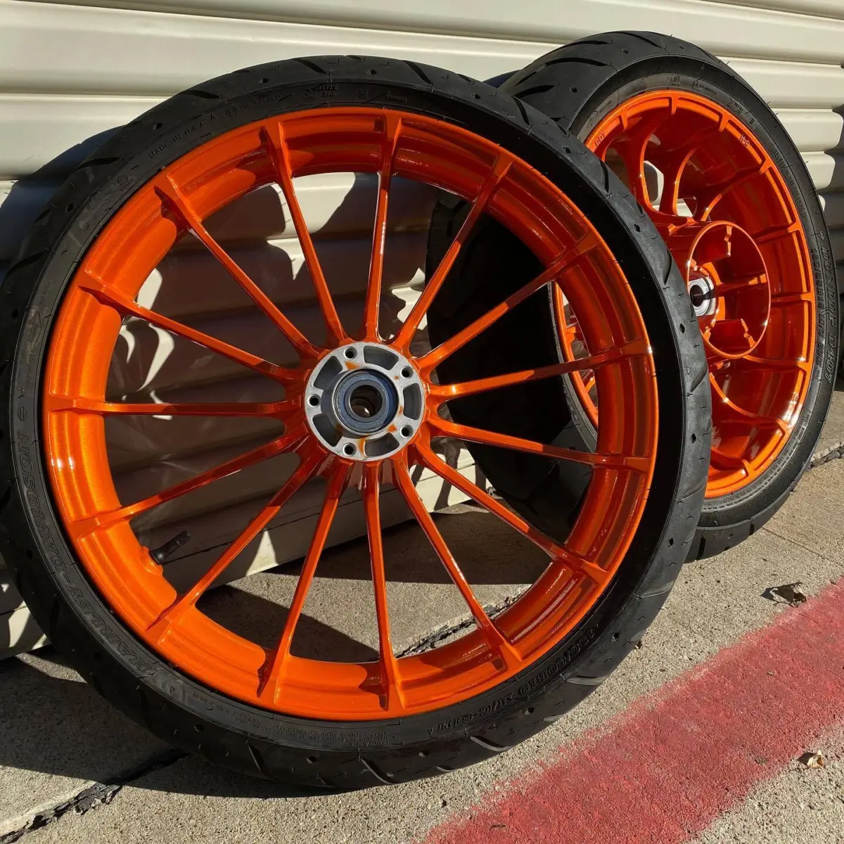 Harley Davidson wheels refinished in Illusion Orange with new bearings and tires changed in-house