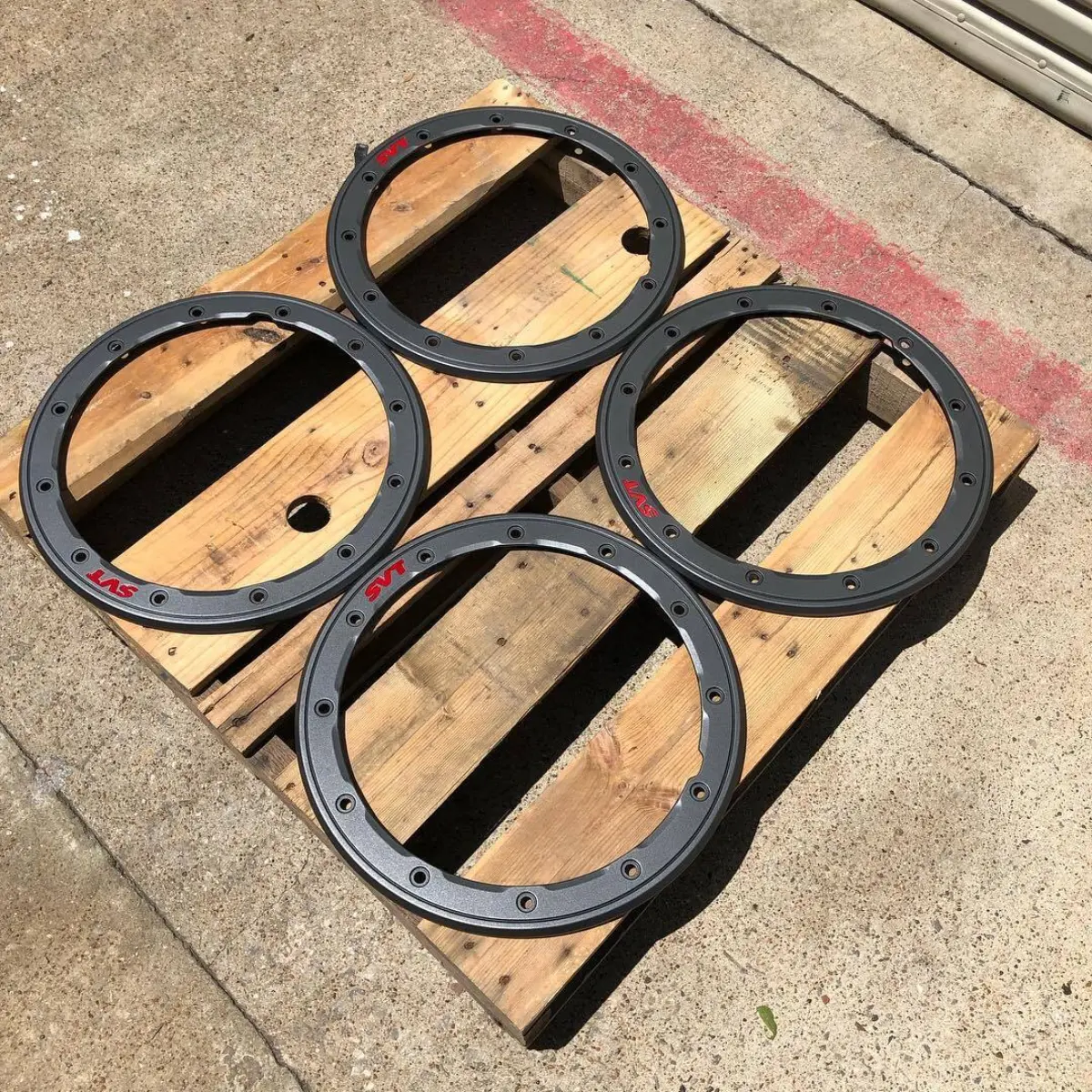 Ford Raptor wheel trim rings refinished in a Satin Gunmetal with 2-tone Red logos