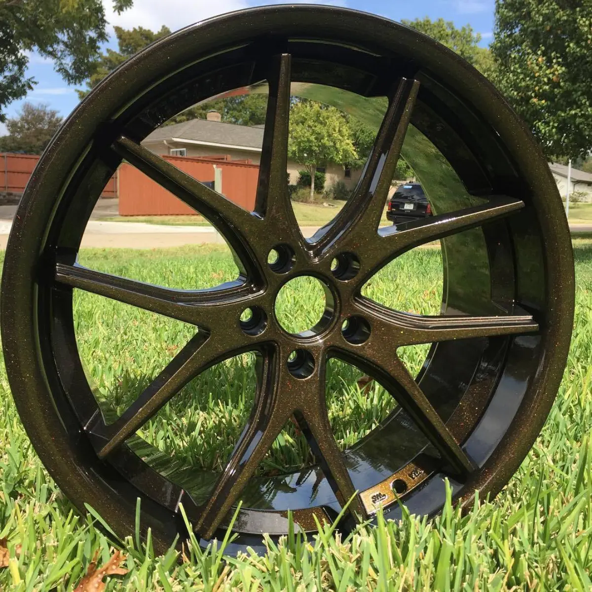 20” Ferrada wheels refinished in a black base coat and custom gold and red flake top coat