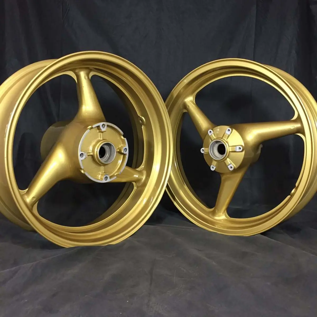 Motorcycle wheels, valve cover, and a set of calipers in our metallic gold