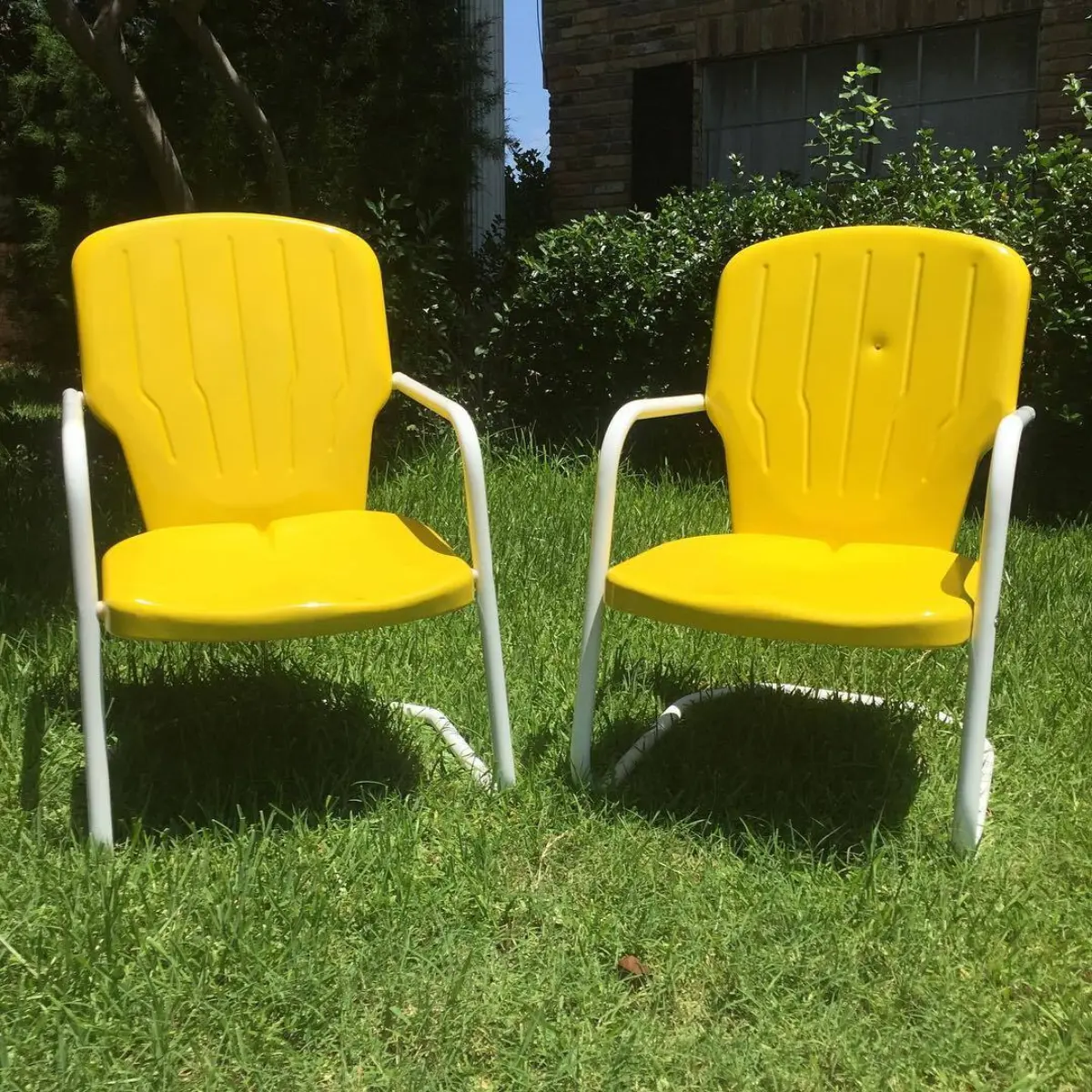 Antique metal lawn chairs refinished in a zinc primer, hot yellow, and RAL-9016. The chair on the right was shot by a customer's grandfather with a .22 and they wanted to preserve the memory. Pretty cool