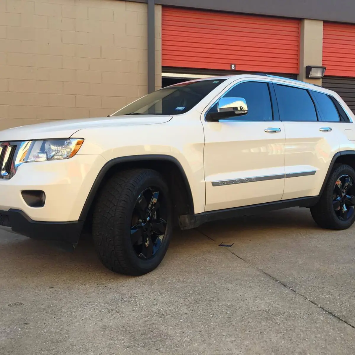 Jeep Grand Cherokee with wet black rims, black lug nuts, black stick-ons, and new center caps on their way