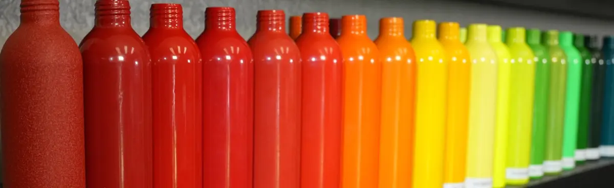 Close-up along the bottom shelf of the color wall: reds through oranges, yellows and greens into teal.